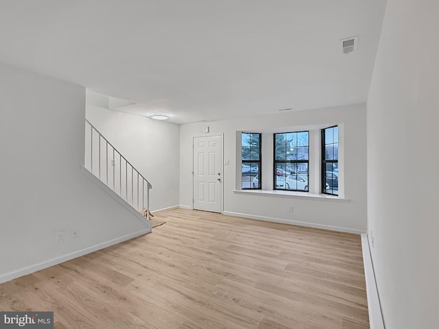 entrance foyer featuring a baseboard radiator and light hardwood / wood-style floors