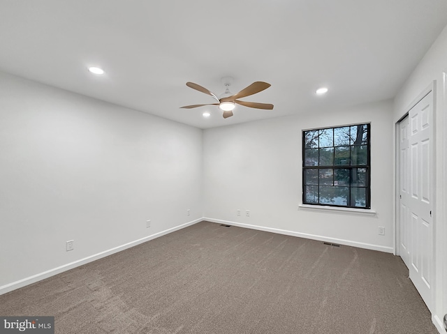 carpeted spare room with ceiling fan