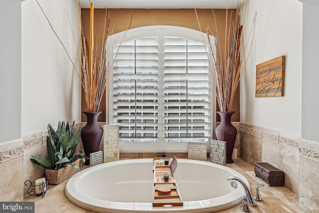 bathroom with a wealth of natural light and tiled bath