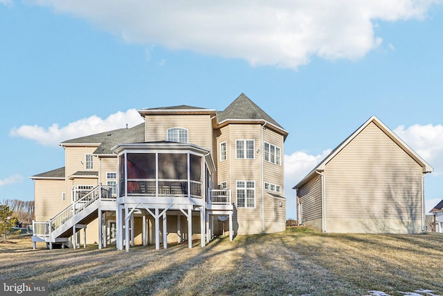 back of property with a yard and a sunroom