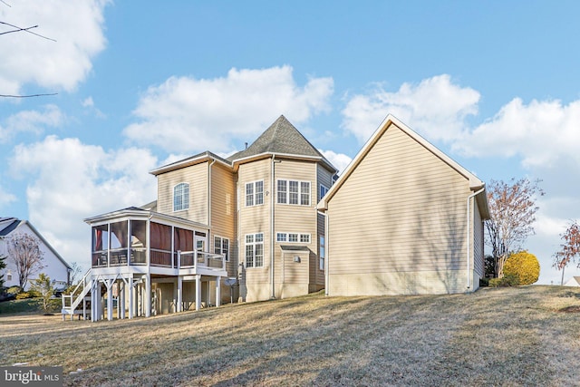 back of house featuring a yard and a sunroom