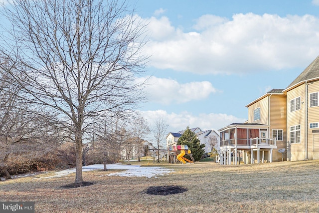 view of yard with a playground and a sunroom