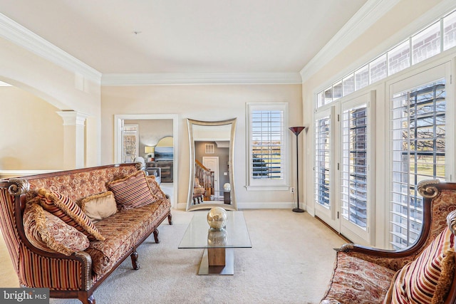 carpeted living room featuring crown molding and ornate columns