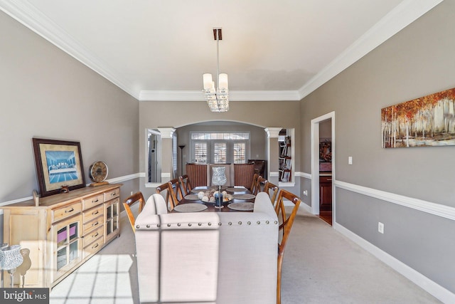 carpeted dining space featuring decorative columns and ornamental molding