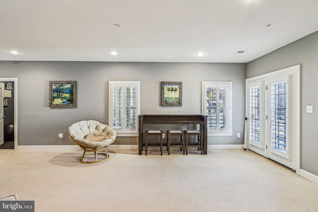 living area featuring light carpet and a wealth of natural light