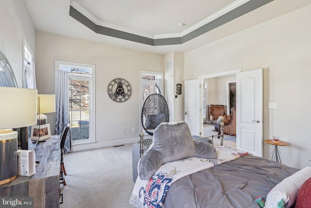 bedroom with crown molding, light colored carpet, a tray ceiling, and multiple windows