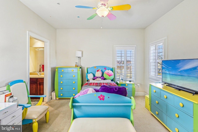 bedroom with ensuite bath, light colored carpet, and ceiling fan