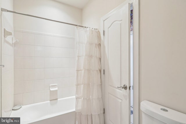 bathroom featuring toilet and shower / bath combo with shower curtain