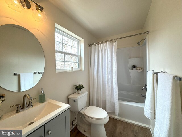 bathroom with vanity, wood finished floors, toilet, and shower / tub combo with curtain