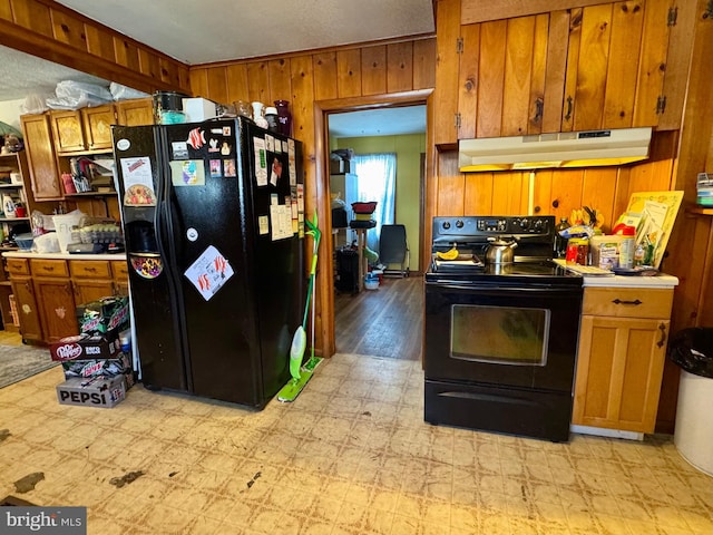 kitchen featuring wooden walls and black appliances