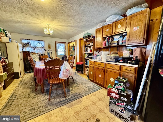 kitchen with a textured ceiling and a notable chandelier