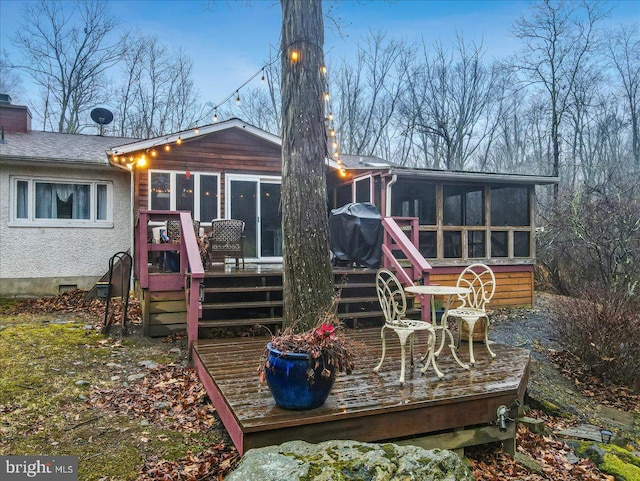 back of house featuring a deck and a sunroom