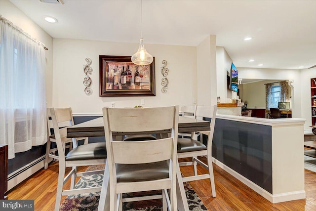 dining space with wood-type flooring, plenty of natural light, and baseboard heating