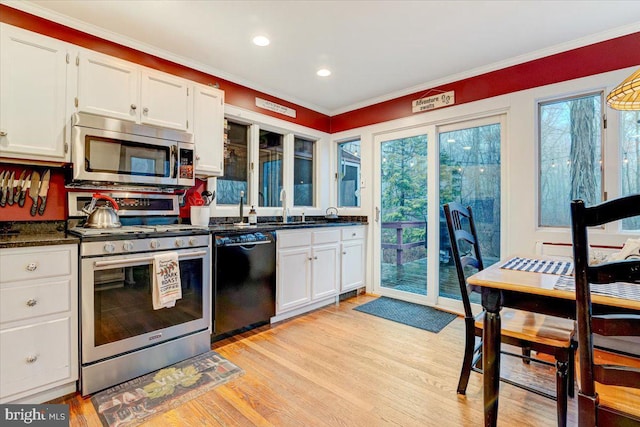 kitchen featuring light wood-type flooring, appliances with stainless steel finishes, sink, and white cabinets