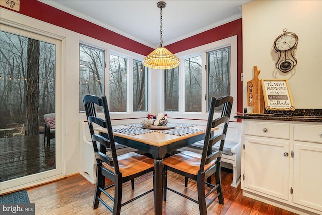 dining space featuring crown molding and wood-type flooring