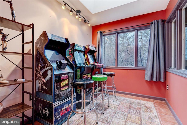 recreation room with light tile patterned floors and rail lighting