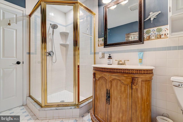 bathroom with vanity, tile patterned floors, tile walls, and walk in shower