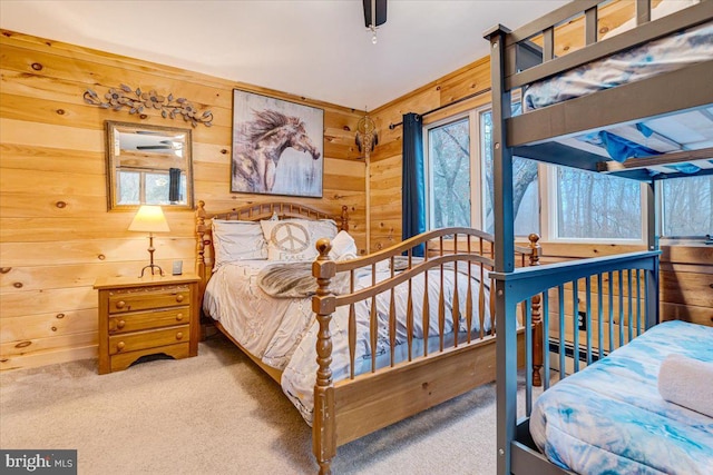 bedroom featuring wooden walls and carpet floors