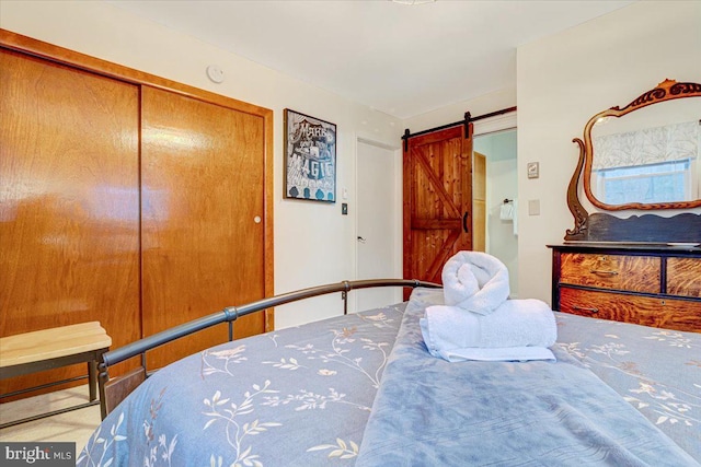 bedroom featuring a barn door and a closet