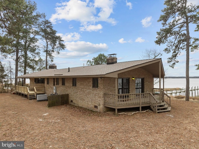 rear view of house featuring a deck with water view