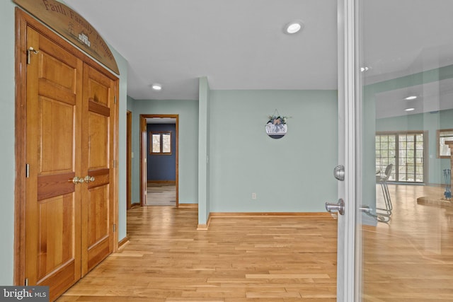 hallway featuring a wealth of natural light and light wood-type flooring