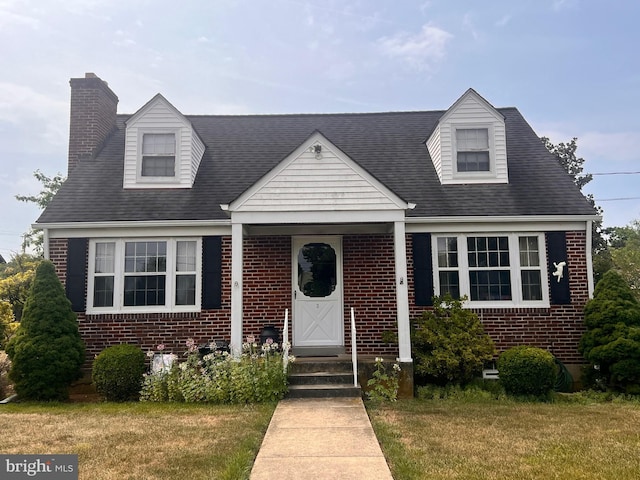 cape cod-style house with a front lawn