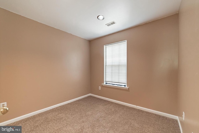 unfurnished room featuring carpet, visible vents, and baseboards