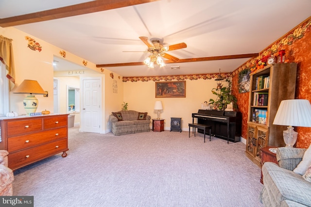 living area with beamed ceiling, ceiling fan, and light carpet