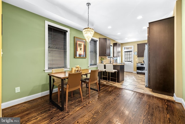 dining space featuring an inviting chandelier, wood-type flooring, and sink