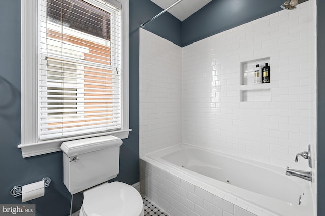 bathroom featuring tiled shower / bath combo, tile patterned floors, and toilet