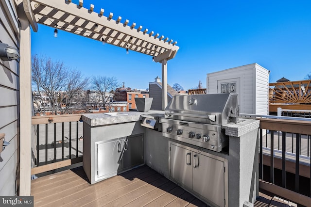 exterior space with a wooden deck, grilling area, and an outdoor kitchen