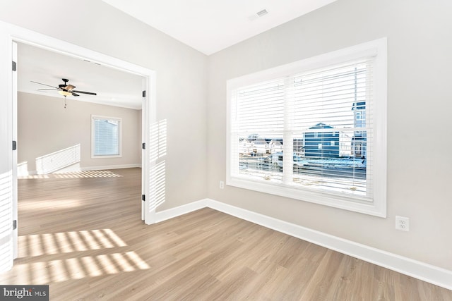 unfurnished room with ceiling fan, a healthy amount of sunlight, and light wood-type flooring