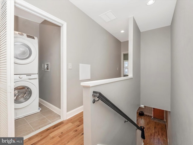 washroom with tile patterned floors and stacked washer / drying machine