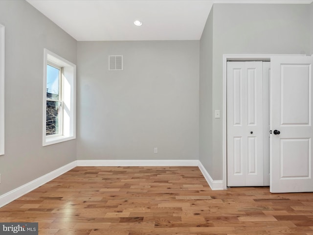 unfurnished bedroom with light wood-type flooring and a closet