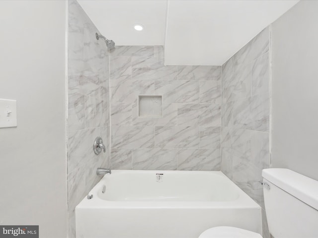 bathroom featuring tiled shower / bath combo and toilet