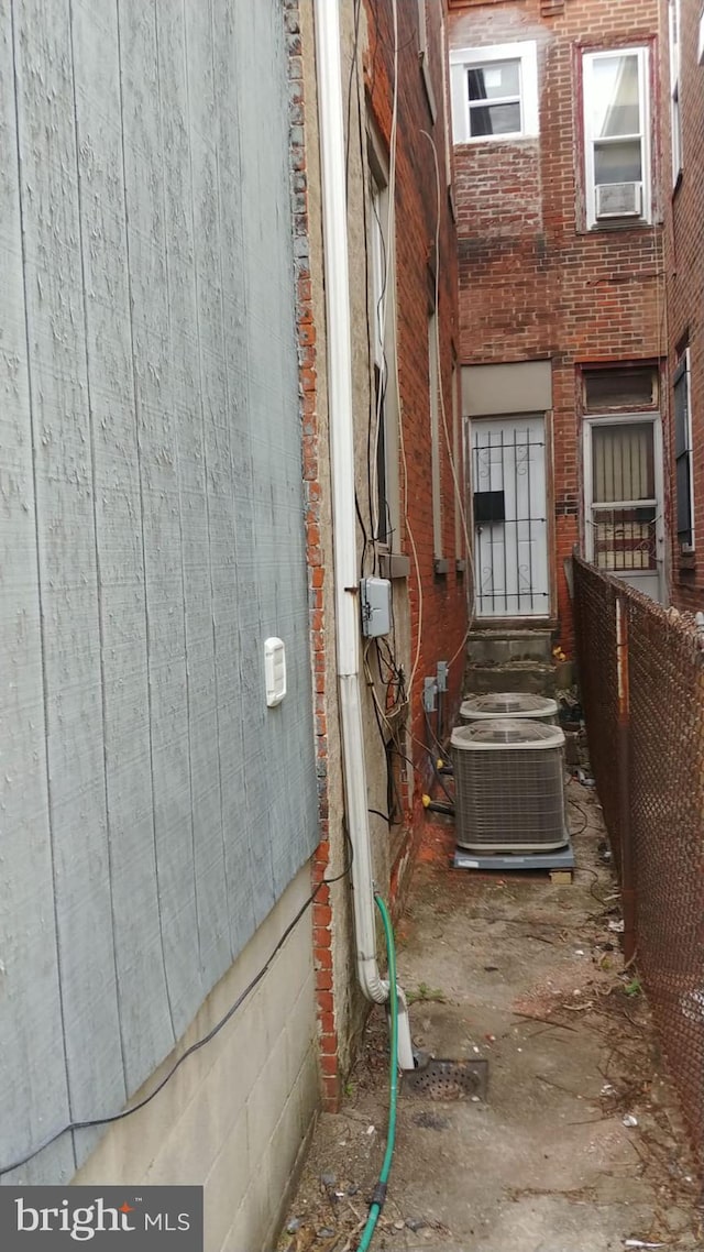 view of home's exterior with cooling unit and central air condition unit