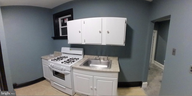 kitchen featuring white cabinetry, sink, and white gas stove