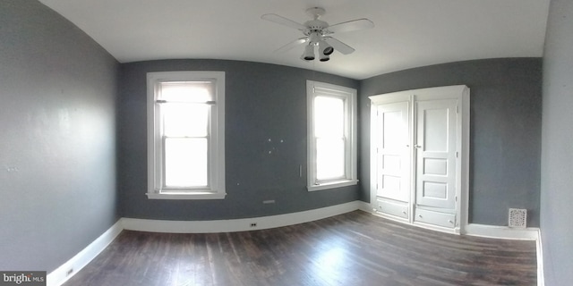 unfurnished bedroom with ceiling fan, lofted ceiling, dark hardwood / wood-style flooring, and multiple windows