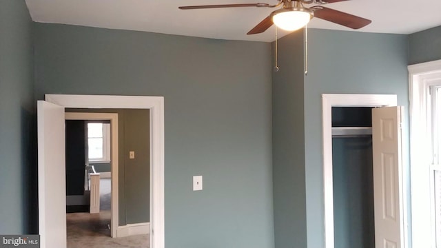 unfurnished bedroom featuring ceiling fan and a closet