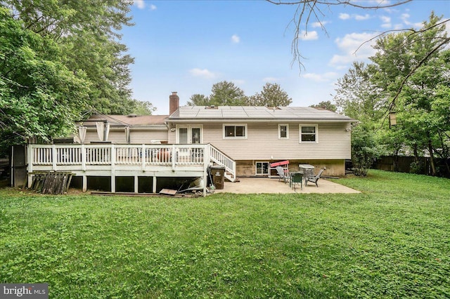 24200 Log House Rd, Gaithersburg, MD 20882 - rear view of house featuring a patio area, a chimney, roof mounted solar panels, and a deck