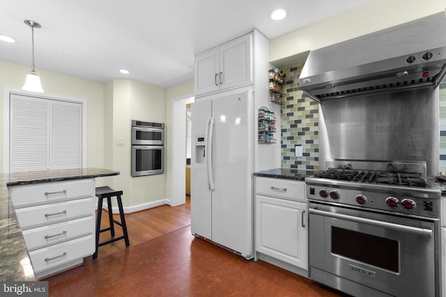 kitchen featuring appliances with stainless steel finishes, white cabinetry, wall chimney range hood, and decorative backsplash