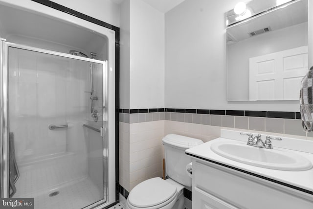 bathroom featuring a shower stall, visible vents, tile walls, and vanity