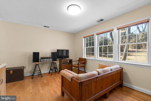 office space featuring baseboards, visible vents, and light wood-style floors