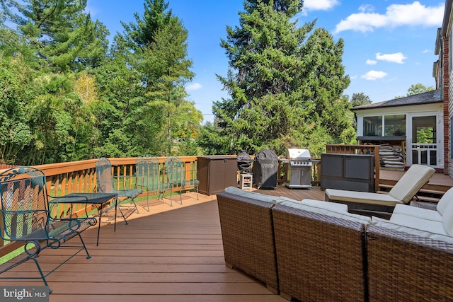 wooden terrace with outdoor lounge area and grilling area