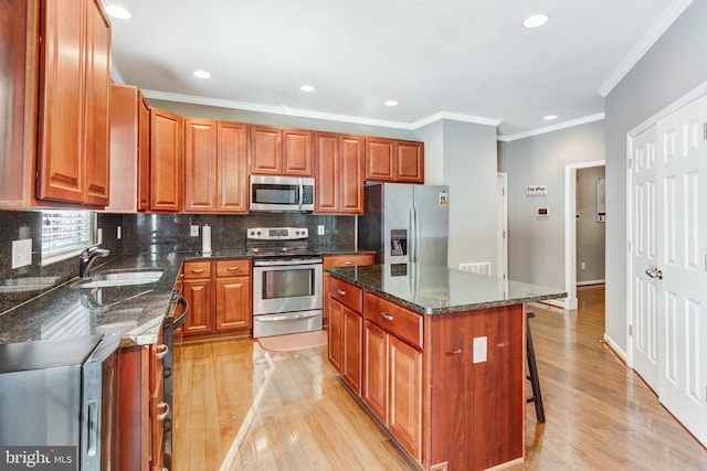 kitchen with dark stone countertops, sink, a center island, and appliances with stainless steel finishes