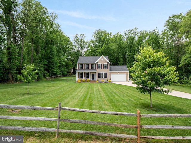 colonial-style house with a garage, a front yard, covered porch, and a rural view