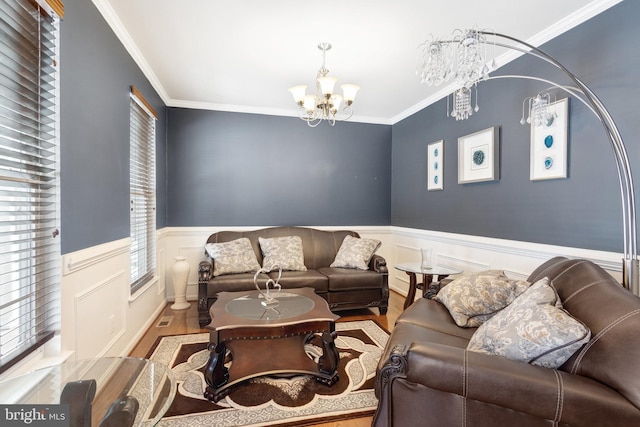 living room featuring ornamental molding, a chandelier, and light hardwood / wood-style floors