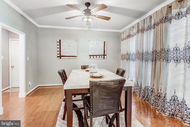 dining room with hardwood / wood-style floors, crown molding, and ceiling fan