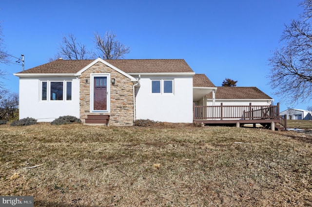 view of front facade with a wooden deck and a front yard