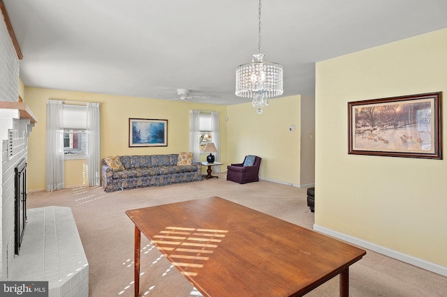 living room with a fireplace, ceiling fan with notable chandelier, and light carpet